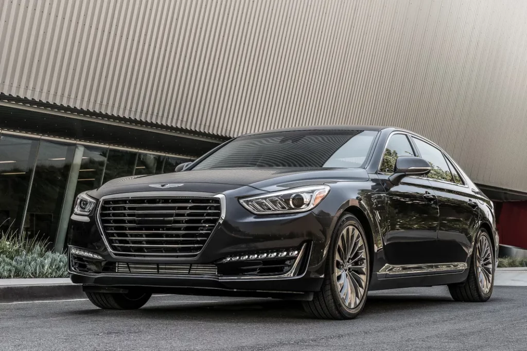 Sleek black Genesis sedan parked in front of a modern building, showcasing its luxury design and advanced features for potential buyers.