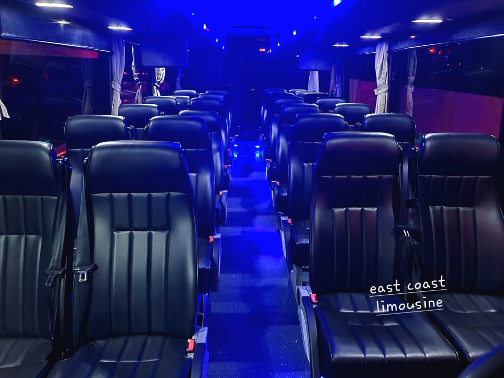 Luxurious black leather seats arranged in rows, illuminated by blue ambient lighting. Showcases the interior of an East Coast Limousine service vehicle.