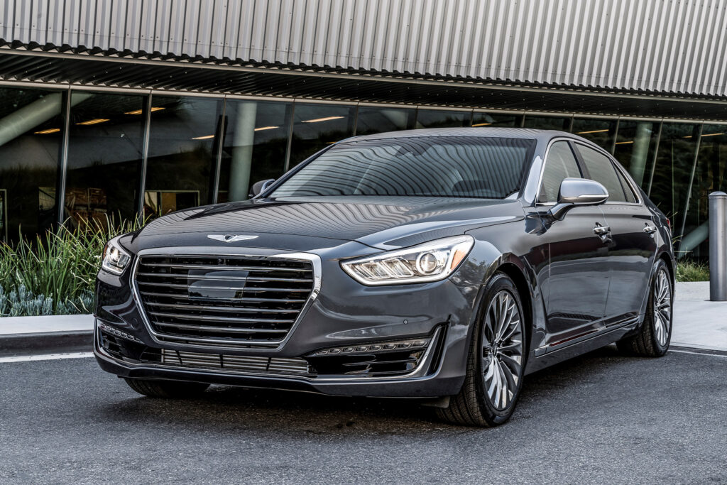 A sleek gray Genesis G80 parked in front of a modern building, showcasing its elegant design and premium features, highlighting luxury automotive artistry.